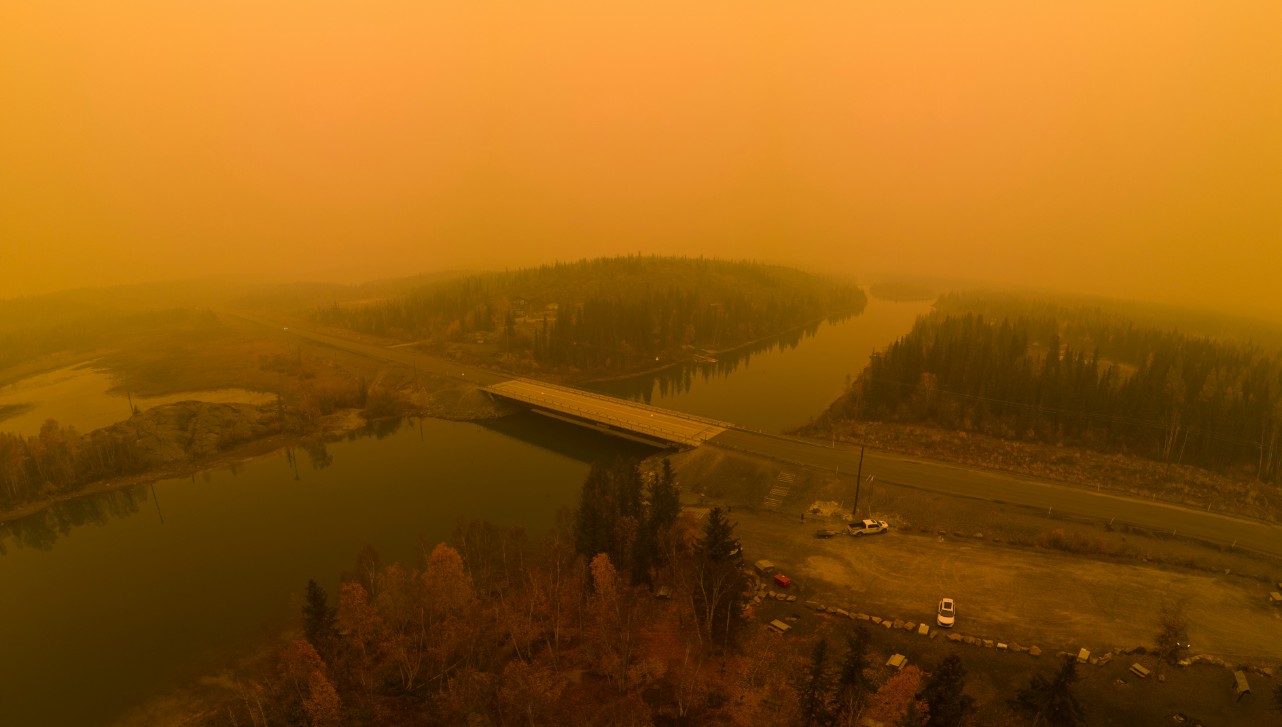 Smooky air and a river as well as trees are visible in this picture